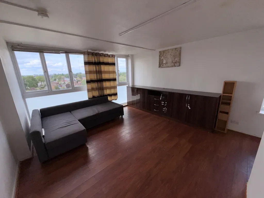 Living room with a corner sofa and a window overlooking trees